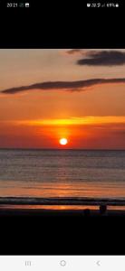 un tramonto sulla spiaggia con il sole che tramonta di Lanta Ala Guest House a Phra Ae beach