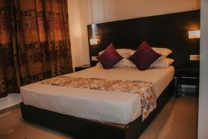 a bedroom with a large bed with red pillows at Aqua Hotel Yala in Yala