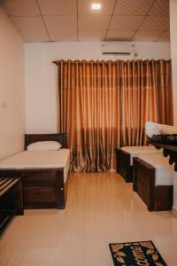 a room with two beds and a window with curtains at Aqua Hotel Yala in Yala