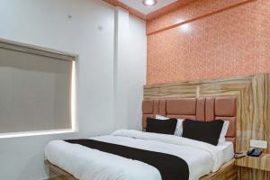 a bedroom with a large bed with a wooden headboard at Flagship JSB Palace in Kakarmatha