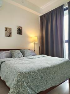 Un dormitorio con una cama grande y una ventana en Luxury Comfort Suite 3BR en Jelutong