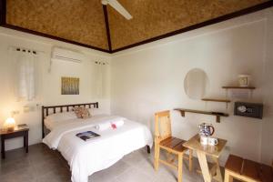 a bedroom with a bed and a desk and a table at Sunz en Coron Resort in Coron