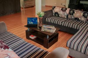 sala de estar con 2 sofás y mesa con ordenador portátil en Aqua Hotel Yala, en Yala
