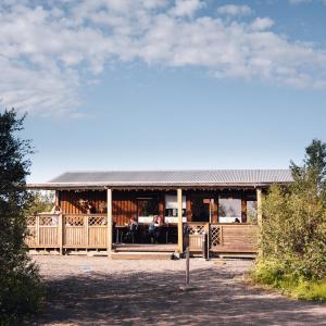 ein Gebäude mit einem Restaurant mit einem Zaun in der Unterkunft Vogar Travel Service in Mývatn