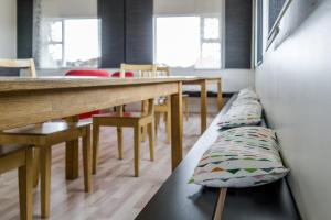 une salle à manger avec des bancs, des tables et des chaises dans l'établissement Vogar Travel Service, à Mývatn