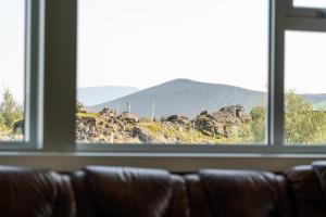 a couch looking out a window at a mountain view at Vogar Travel Service in Myvatn