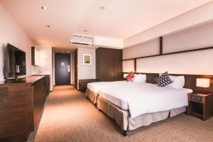 京都市にあるKABIN Kyotoのベッド2台、薄型テレビが備わるホテルルームです。