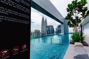 un panneau sur le côté d'un bâtiment avec piscine dans l'établissement Royce KLCC Kuala Lumpur City Centre by Dormeo Destinations, à Kuala Lumpur