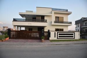 een groot wit huis met een houten hek bij DHA 2 House, Islamabad in Islamabad