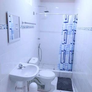 bagno bianco con servizi igienici e lavandino di HospedajesPerú a Zorritos