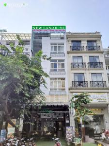 a tall white building with a sign on it at NEW LAND Apartment 2 - Phu My Hung in Ho Chi Minh City
