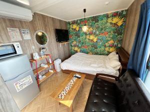 een kleine kamer met een bed en een tafel bij Shiawaseninaru Kourijima no Yado in Nakijin
