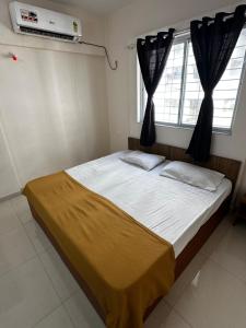 um quarto com uma cama grande e uma janela em Blissful stays em Pune