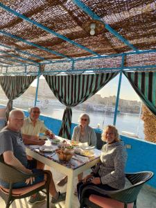 un grupo de personas sentadas en una mesa en Jamaica Guest House en Asuán