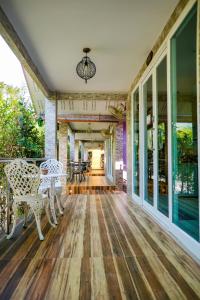 een lege veranda met witte stoelen en een tafel bij Happy Garden Resort Betong in Betong