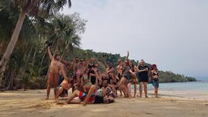 een groep mensen die poseren voor een foto op het strand bij Freedom home in Ko Chang