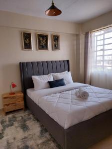 Un dormitorio con una cama grande y una ventana en Rawin Homes, en Nyeri