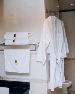 a bathroom with white towels on a rack at Gold Crest Hotel in Mwanza
