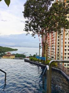 Jelutong的住宿－Luxury Comfort Suite 3BR，一座高楼前的游泳池