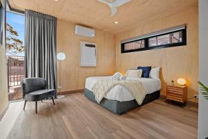 Tasman Holiday Parks - St Helens في سانت هيلينز: غرفة نوم بسرير وكرسي ونافذة