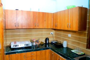 a kitchen with wooden cabinets and a black counter top at Choudhary Mansion in Rāmnagar