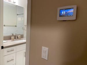 a bathroom with a television hanging on the wall at New! Cozy Gated 3BR, 2BA Vacation Home in Rosemead