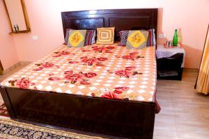 a large bed with a quilt and pillows on it at Choudhary Mansion in Rāmnagar