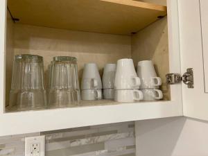 a bunch of glass cups sitting on a shelf at New! Cozy Gated 3BR, 2BA Vacation Home in Rosemead