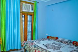 1 dormitorio con 1 cama en una habitación con paredes azules en Choudhary Mansion en Rāmnagar