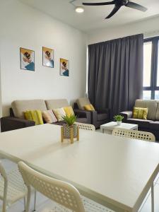 a living room with a white table and chairs at Luxury Comfort Suite 3BR in Jelutong