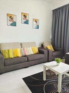 a living room with a couch and a table at Luxury Comfort Suite 3BR in Jelutong