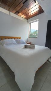 a large white bed in a room with a window at Apto - 1802B - Vista Única in Bogotá