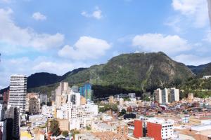 a view of a city with a mountain in the background at Apto - 1802B - Vista Única in Bogotá