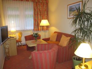 ein Wohnzimmer mit einem Sofa und einem Tisch in der Unterkunft Kurpark Flair Hotel Im Ilsetal in Ilsenburg