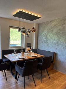 een eetkamer met een tafel en stoelen en een schilderij bij GreenView Appartement in Wiesing