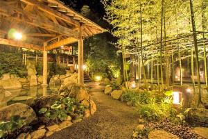 un jardín por la noche con rocas y un edificio en Rooms平尾 en Fukuoka