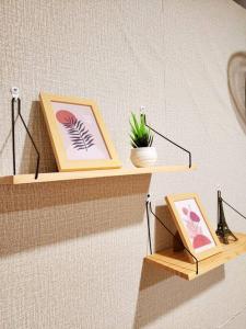 a shelf with two pictures and a potted plant on it at 207:Homely room in apartment Near BTS Kasetsart U. in Bangkok