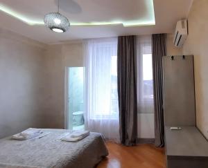 1 dormitorio con cama y ventana grande en Makos Guest House, en Kutaisi
