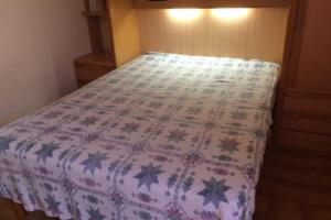 Una cama en un dormitorio con una manta. en Cap d' Agde Naturist Hélio-village villa 58, en Cap d'Agde