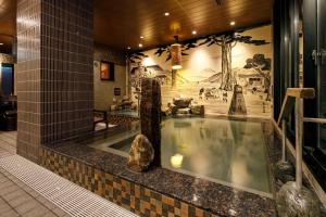 a swimming pool in a building with a mural at Dormy Inn Express Toyohashi in Toyohashi