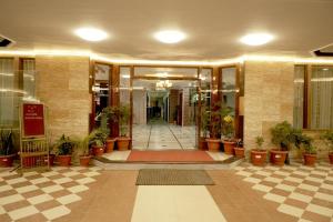 a lobby of a building with potted plants at Hotel Bhawani International in Katra
