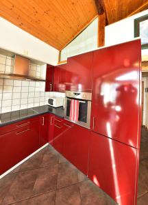 a kitchen with red cabinets and a red refrigerator at Douillet nid d'aigle in Daillon