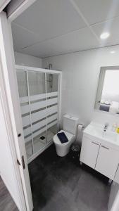 Baño blanco con aseo y lavamanos en Lofts 4Towers - La Paz, en Madrid