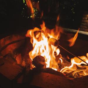 a fire pit with a hot dog on a stick in it at Umbral Hotel Boutique in Villavicencio