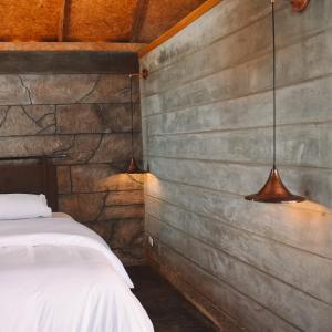 sypialnia z łóżkiem i 2 lampkami na ścianie w obiekcie Umbral Hotel Boutique w mieście Villavicencio