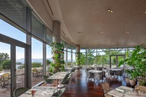 a restaurant with tables and chairs and large windows at Ananti at Namhae in Namhae