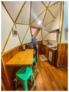 Domos Frutillar في فروتيلار: مطبخ مع طاولة خشبية في خيمة القبة