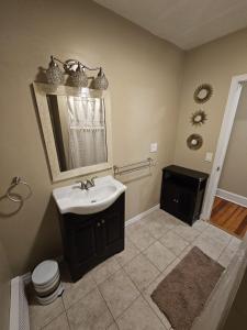 ein Badezimmer mit einem Waschbecken, einem Spiegel und einem WC in der Unterkunft Providence Place Apartment in Providence