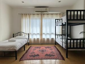 a bedroom with two bunk beds and a rug at Tangerine Dream Guesthouse in Ko Phangan