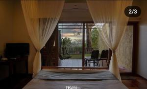een slaapkamer met een bed met gordijnen en een balkon bij Nisarg Resort in Kolhapur